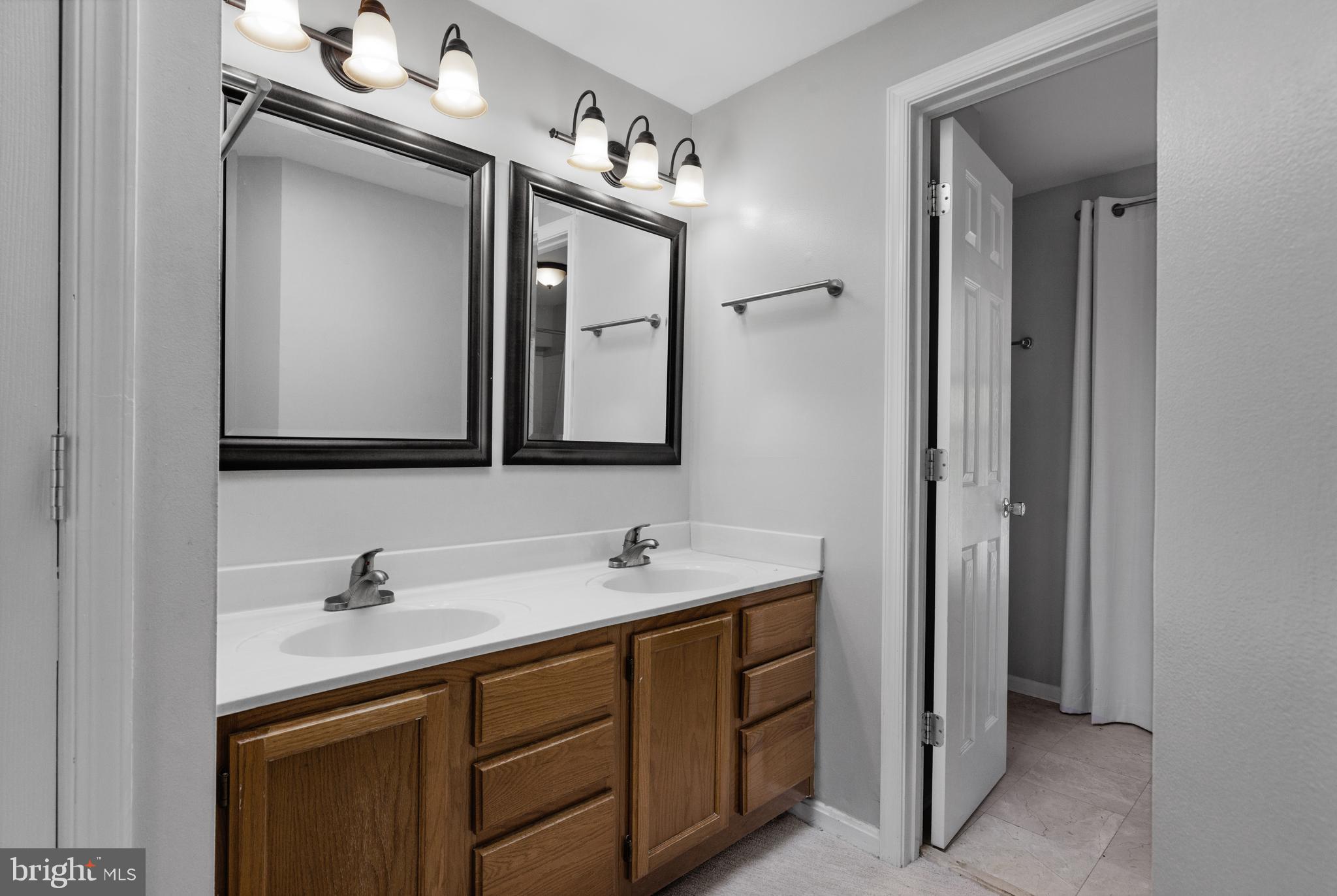 1729 Quietree Drive Reston, VA 20194 - Photo 18 of 22 a bathroom with a double vanity sink and a mirror