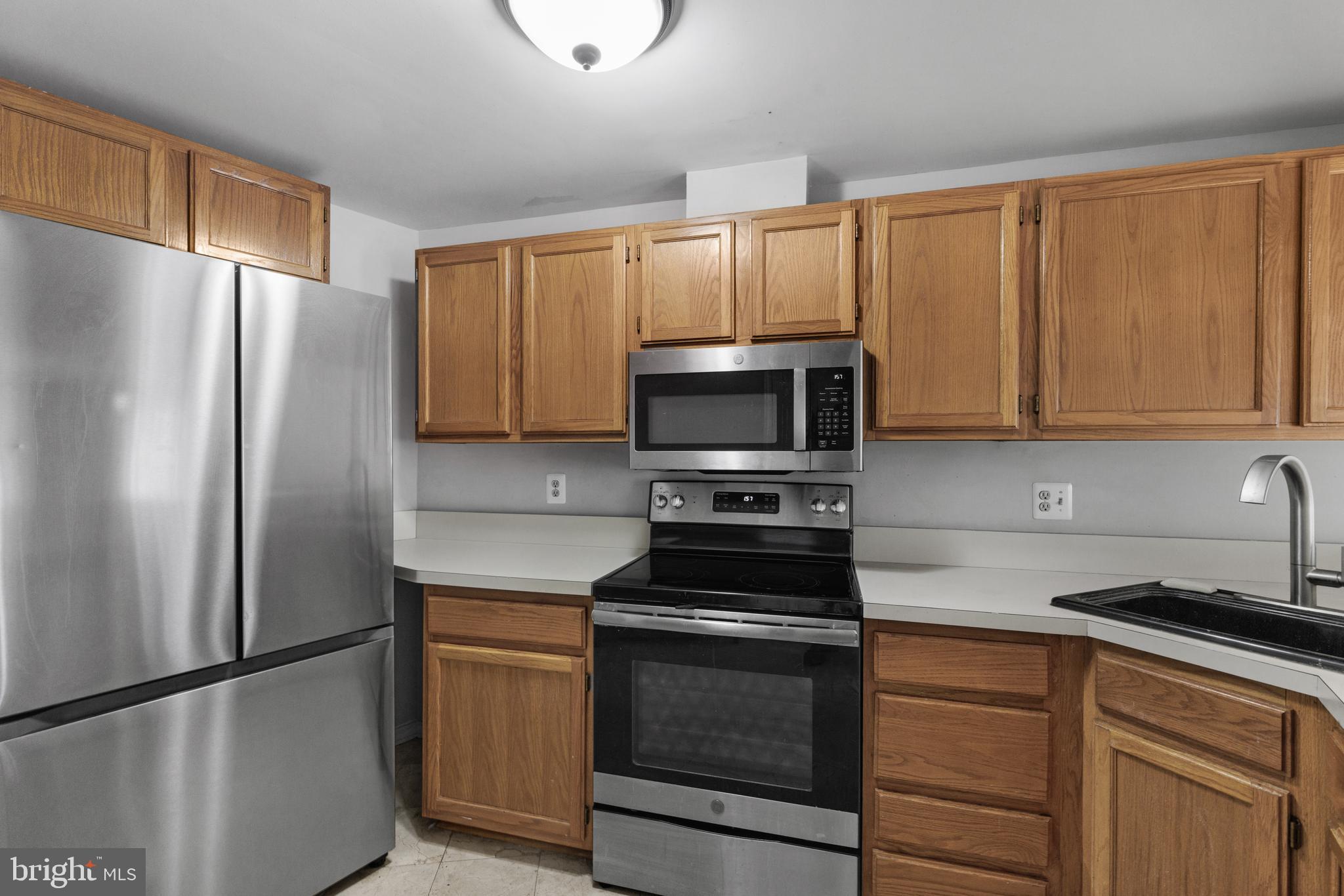 1729 Quietree Drive Reston, VA 20194 - Photo 7 of 22 a kitchen with white cabinets stainless steel appliances and a refrigerator