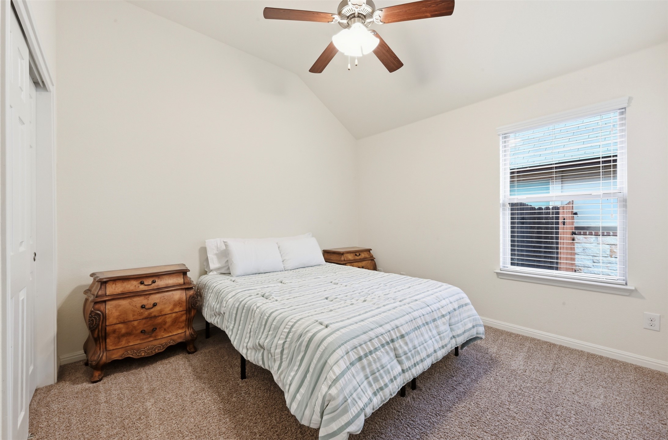 13116 Alans Way Manchaca, TX 78652 - Photo 17 of 25 Vaulted ceiling room featuring a ceiling fan with integrated lighting, a single window with blinds, and neutral carpet flooring