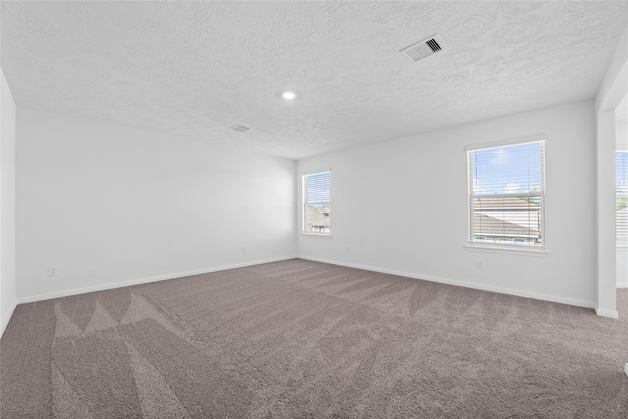 3519 Rocky Aspen Dr Spring Spring, TX 77373 - Photo 15 of 29 Relax and recharge in this stunning primary suite! This expansive room offers plush carpeting, neutral-toned walls, high ceilings, large windows fitted with privacy blinds, and an added sitting area—perfect for unwinding after a long day.