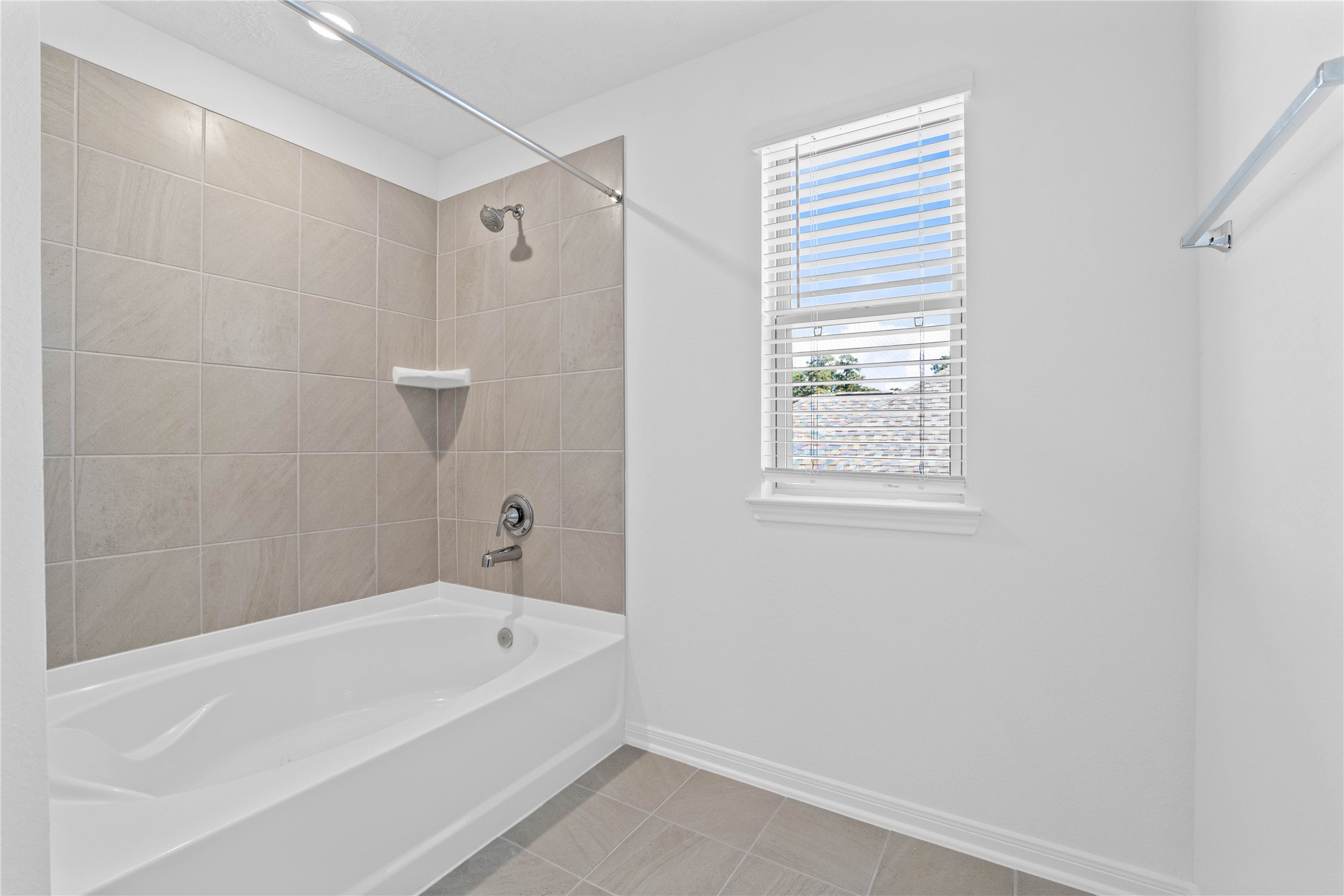 3519 Rocky Aspen Dr Spring Spring, TX 77373 - Photo 19 of 29 This additional view of the primary bath highlights an oversized tub/shower combination with tile surround, and a large window with blinds that offers both natural light and privacy.