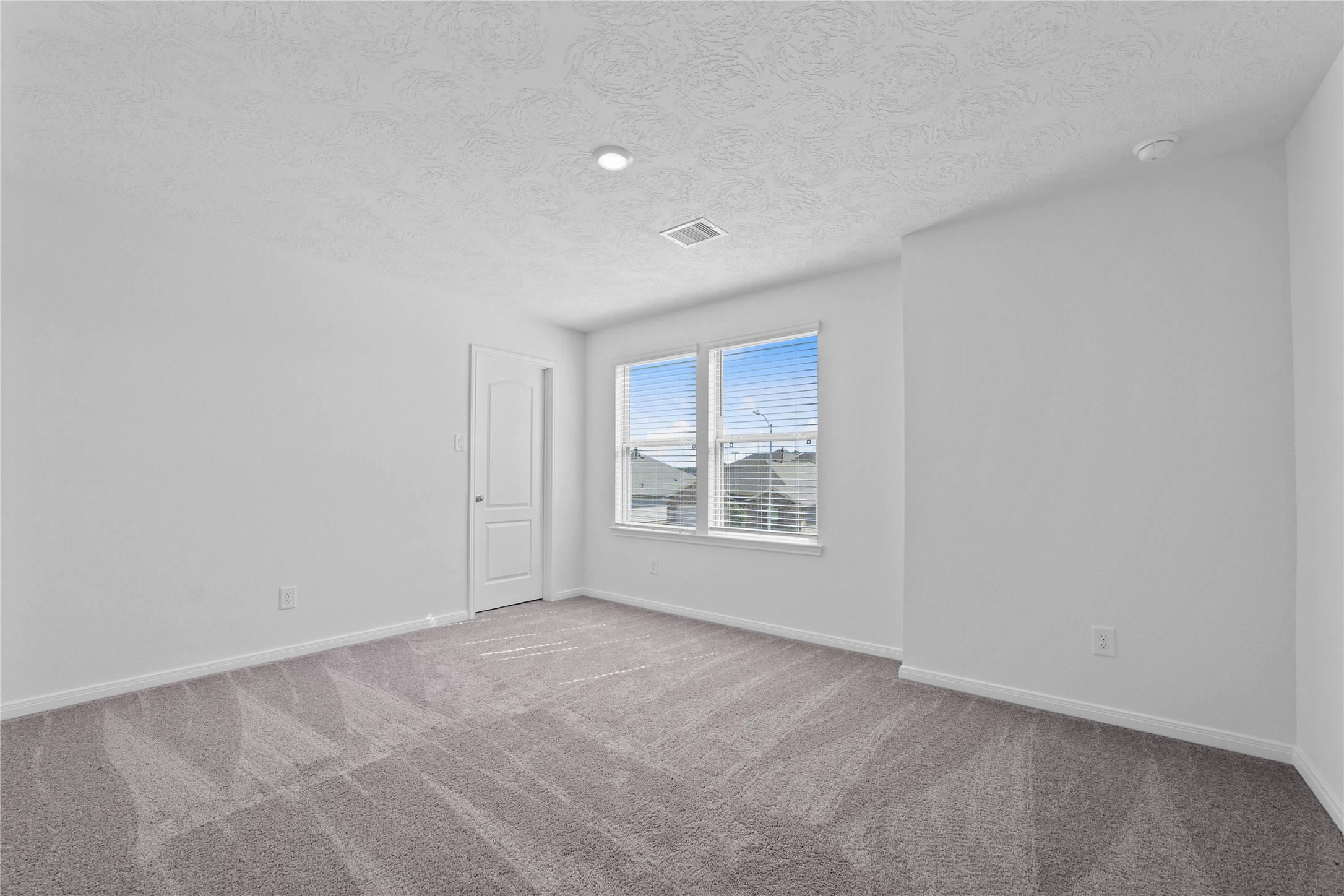 3519 Rocky Aspen Dr Spring Spring, TX 77373 - Photo 20 of 29 This secondary bedroom offers comfort and style with plush carpeting, neutral paint tones, recessed lighting, large windows with blinds, and a walk-in closet.