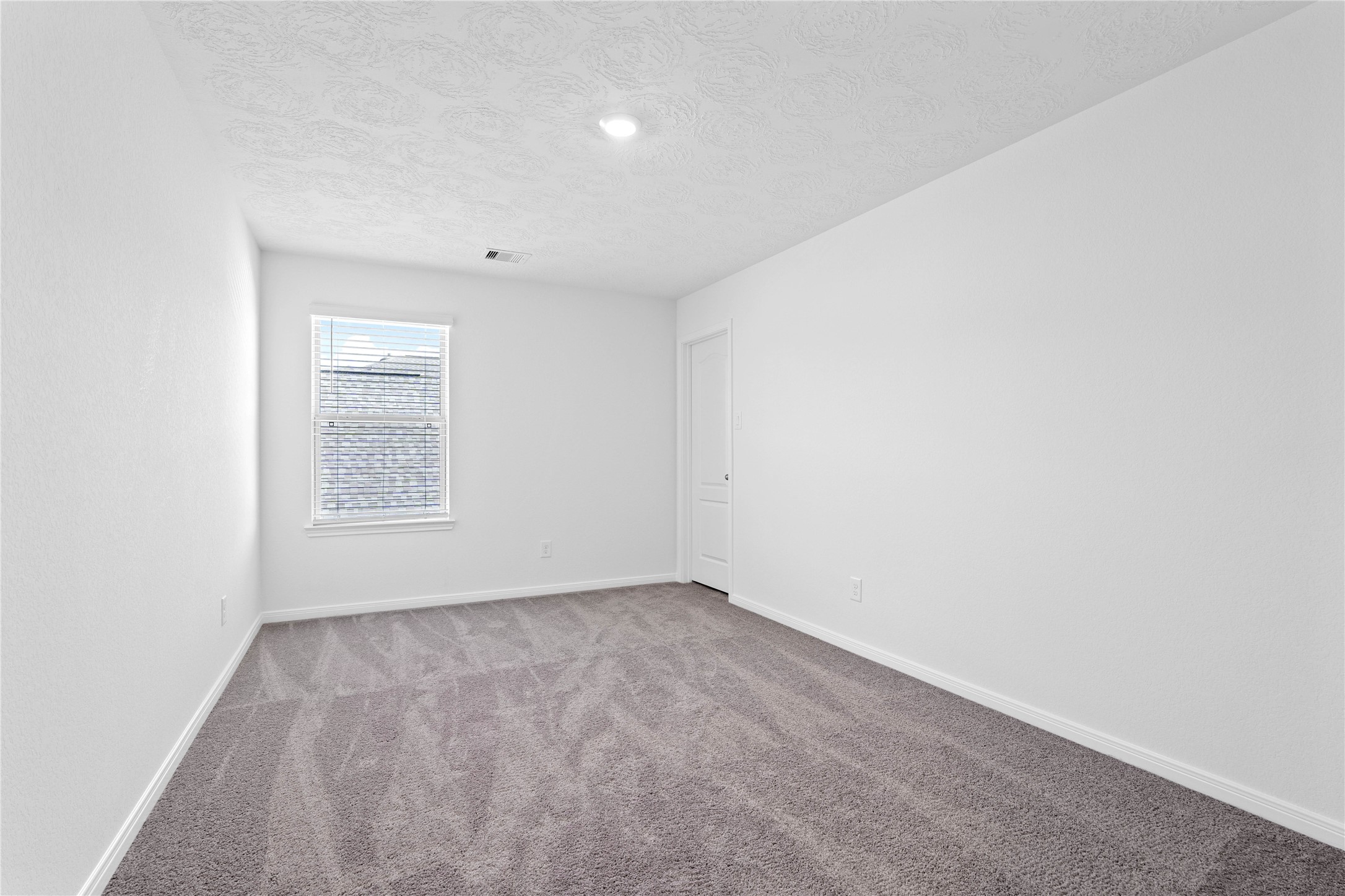 3519 Rocky Aspen Dr Spring Spring, TX 77373 - Photo 22 of 29 This secondary bedroom offers comfort and style with plush carpeting, neutral paint tones, recessed lighting, a large window with blinds, and a walk-in closet.