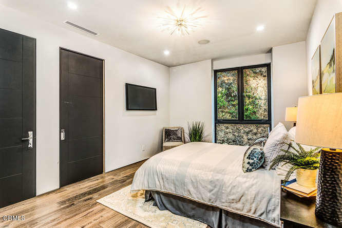 1375 Wierfield Drive Pasadena, CA 91105 - Photo 65 of 68 a bedroom with a bed and a flat tv screen on dresser