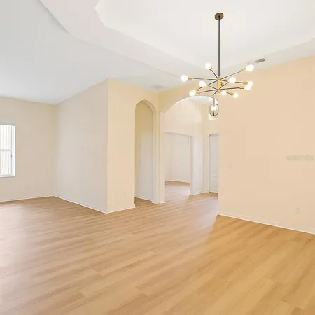 a view of an empty room with window and a ceiling fan