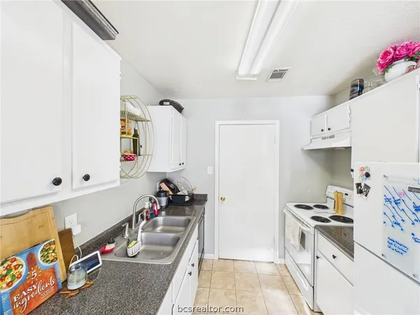 a kitchen with a sink stove and cabinets