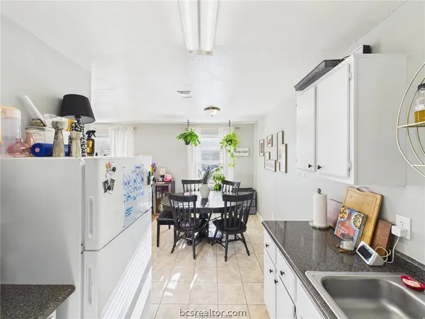 a kitchen with granite countertop a sink appliances and dining table