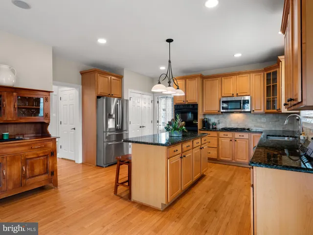 a view of a dining room and livingroom with furniture wooden floor a chandelier