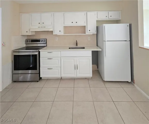 a kitchen with white cabinets a sink and white appliances