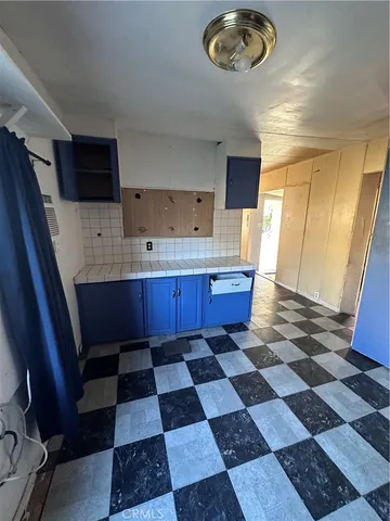 a room with a black white checkered floor with a dining table and chairs