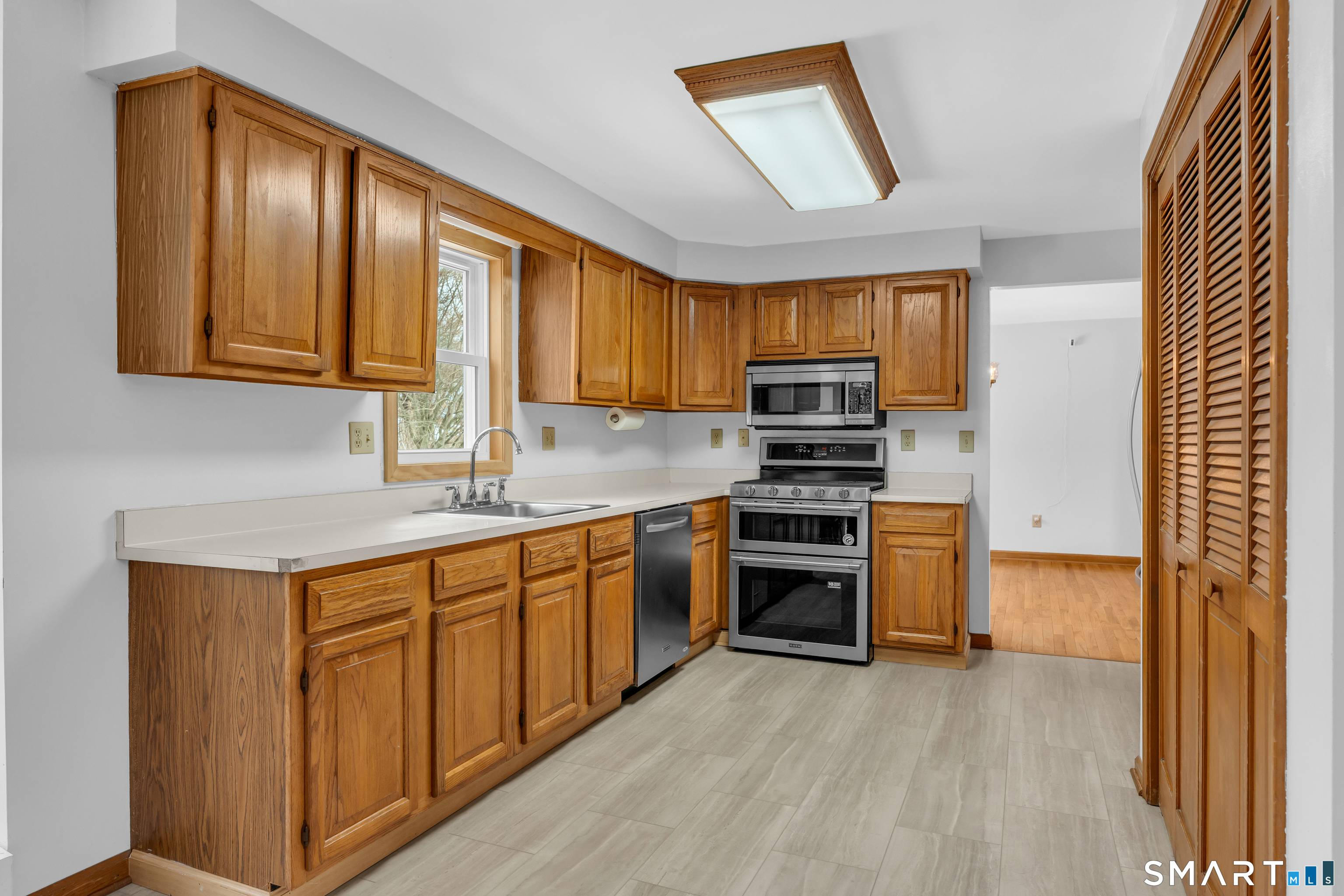 26 Pent Road Branford, CT 06405 - Photo 3 of 28 a kitchen with granite countertop wooden cabinets a stove top oven and stainless steel appliances