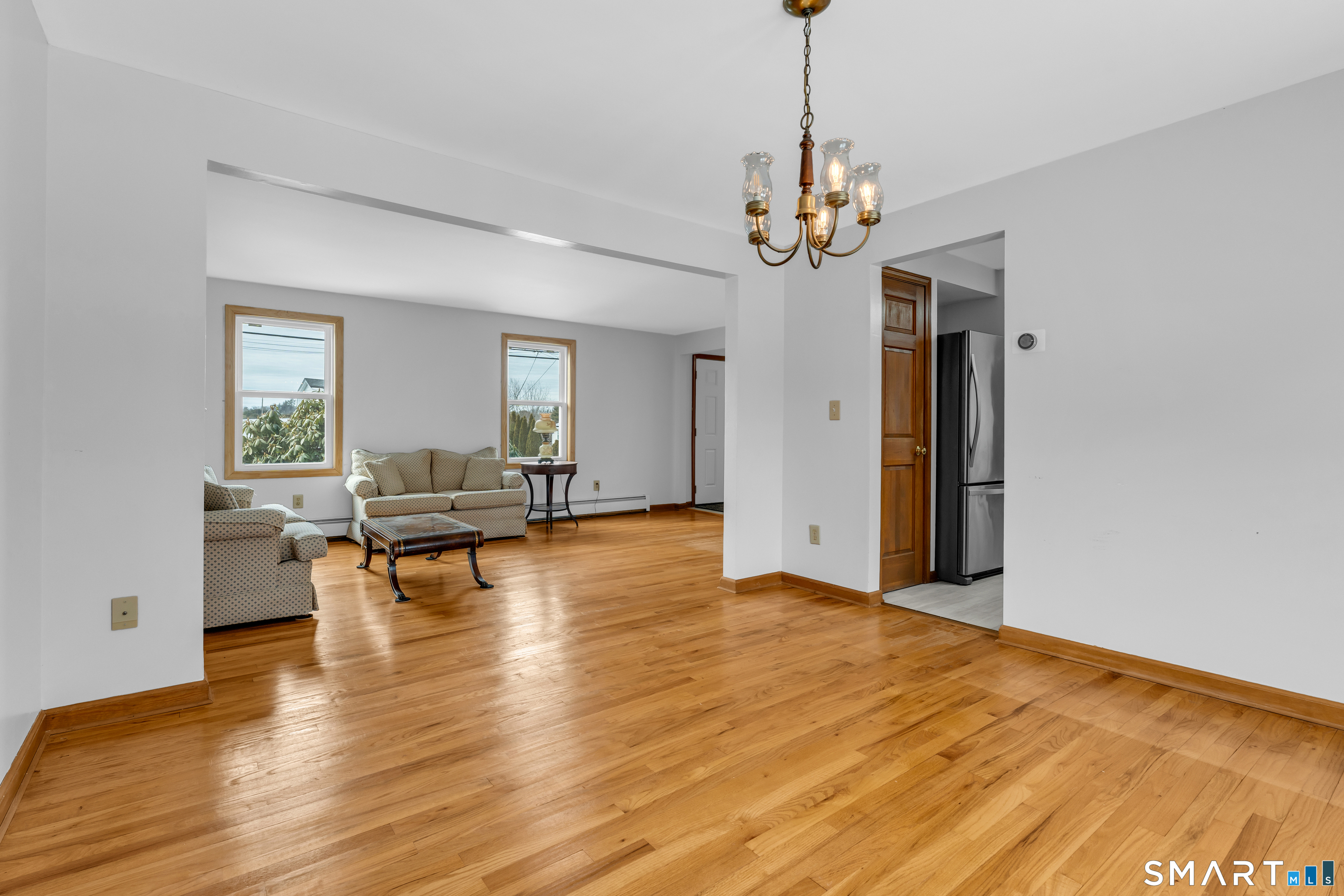 26 Pent Road Branford, CT 06405 - Photo 6 of 28 a view of a livingroom with a dining table chairs and couches with wooden floor