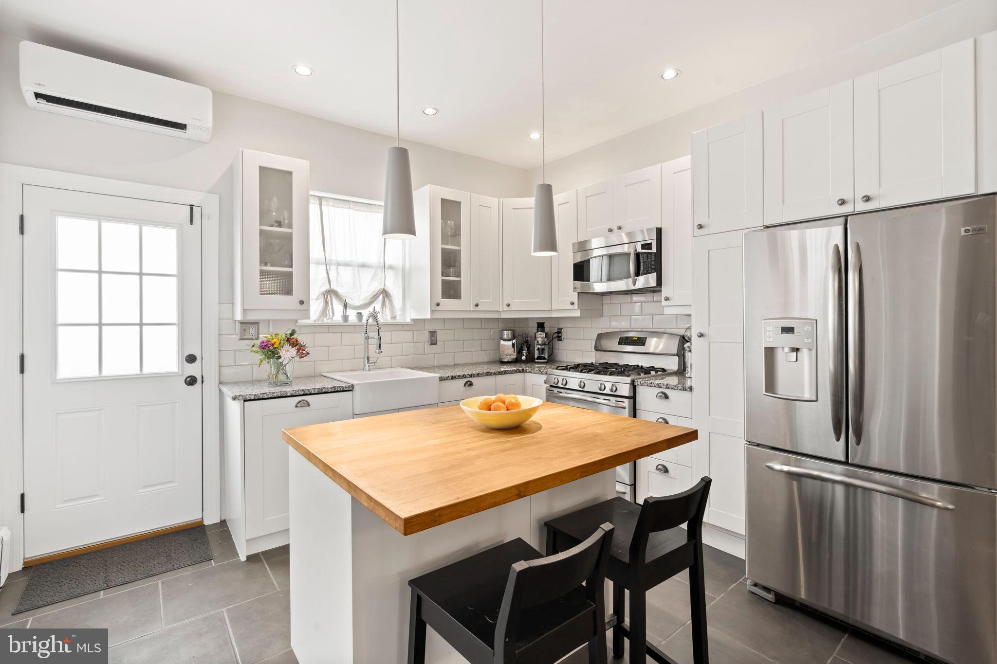 1728 South 13th Street Philadelphia, PA 19148 - Photo 18 of 31 a kitchen with stainless steel appliances granite countertop a refrigerator a sink a stove a dining table and chairs
