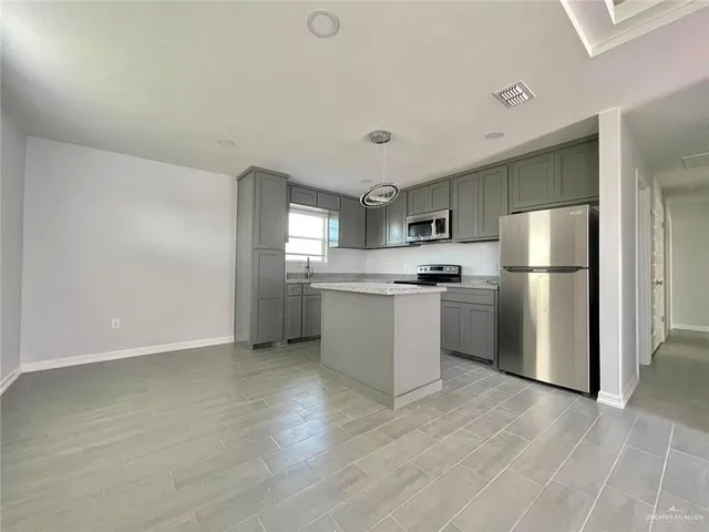 a kitchen with stainless steel appliances a refrigerator and a stove top oven