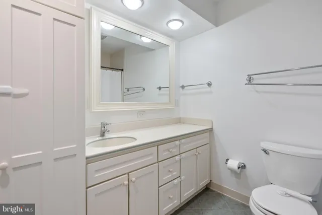 a bathroom with a granite countertop sink a toilet and a mirror