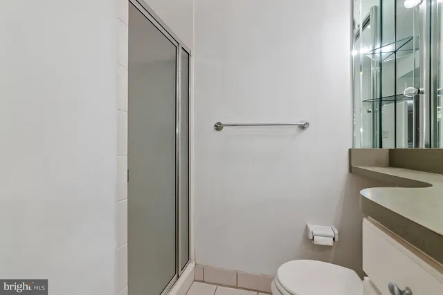 a bathroom with a sink a toilet a mirror and shower