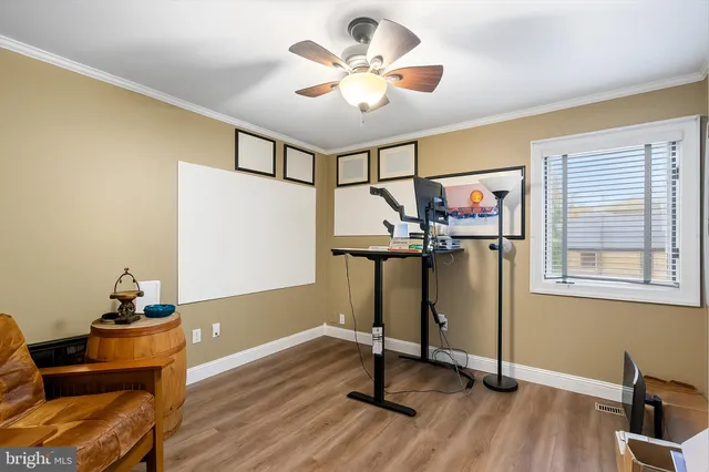 a workspace room with furniture and wooden floor