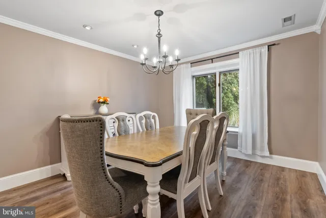 a view of a dining room with furniture a chandelier and wooden floor