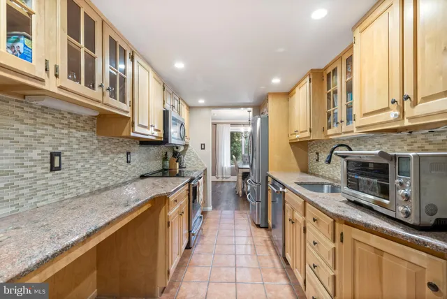 a kitchen with stainless steel appliances granite countertop a sink and a stove