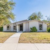a front view of house with yard and trees around