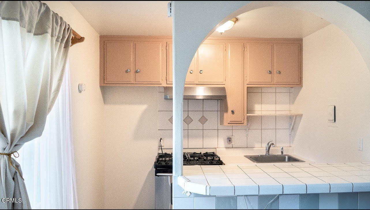 1920 North H Street, Unit 235 Oxnard, CA 93036 - Photo 7 of 13 a kitchen with a sink a stove and a refrigerator