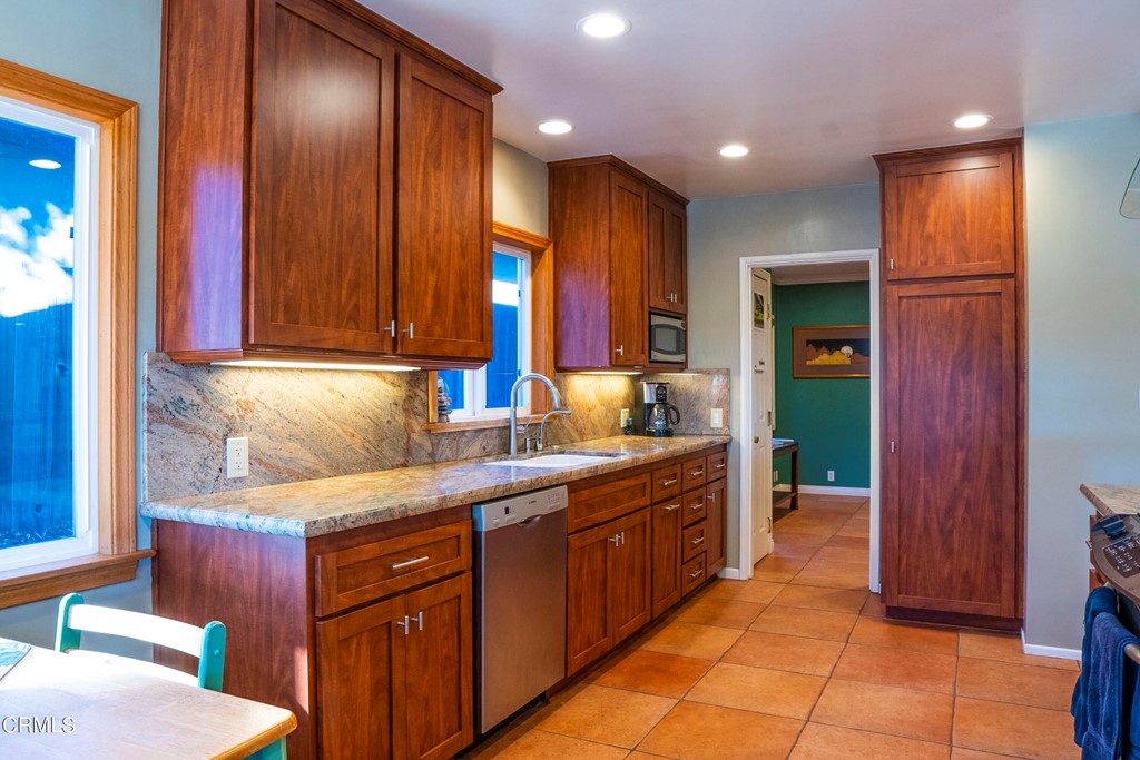 4155 Aralia Road Altadena, CA 91001 - Photo 7 of 28 a kitchen with stainless steel appliances granite countertop wooden cabinets a sink and dishwasher