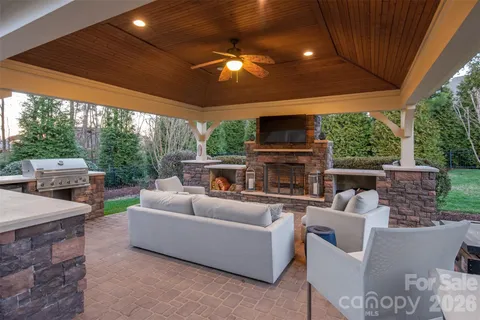 a living room with furniture a fireplace and a floor to ceiling window