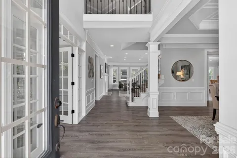 a view of a hallway with wooden floor and a glass door