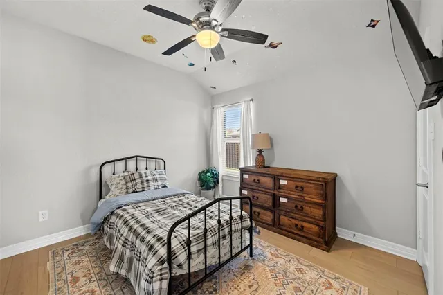 a bedroom with a bed a window and a flat screen tv