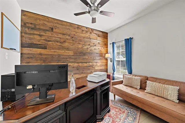 a work room with furniture and a ceiling fan