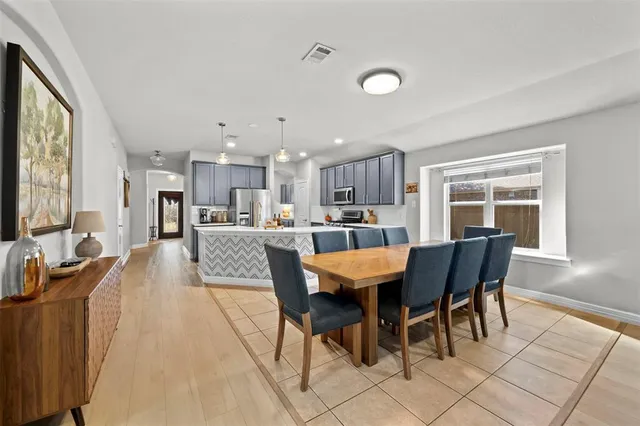 a large kitchen with kitchen island a dining table and chairs