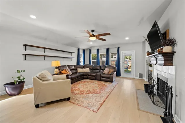 a living room with furniture a fireplace and a flat screen tv