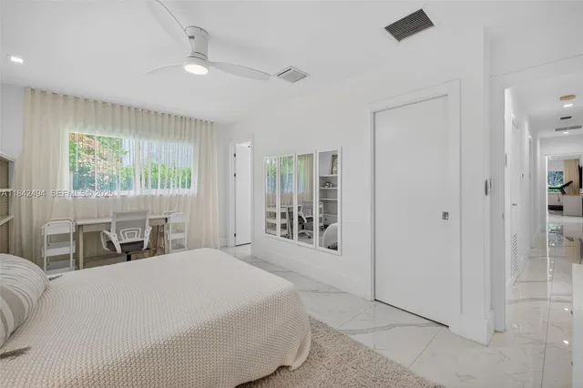 a large bedroom with a bed and a large window