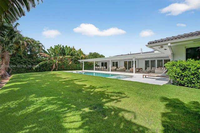 a view of house with a big yard and potted plants