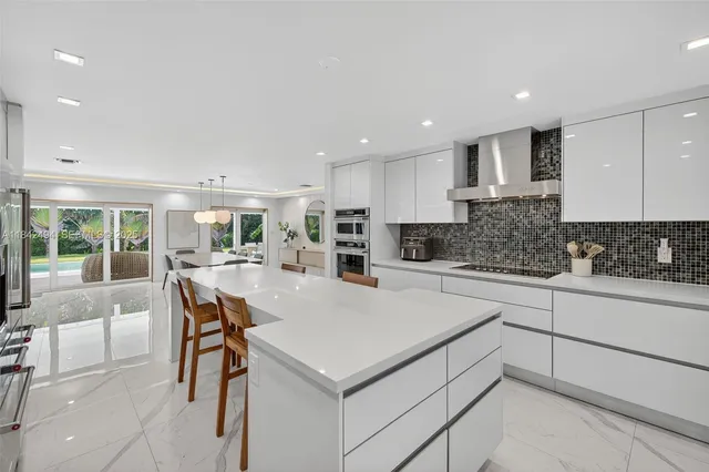 a kitchen with a refrigerator a stove top oven a sink and a dining table with wooden floor