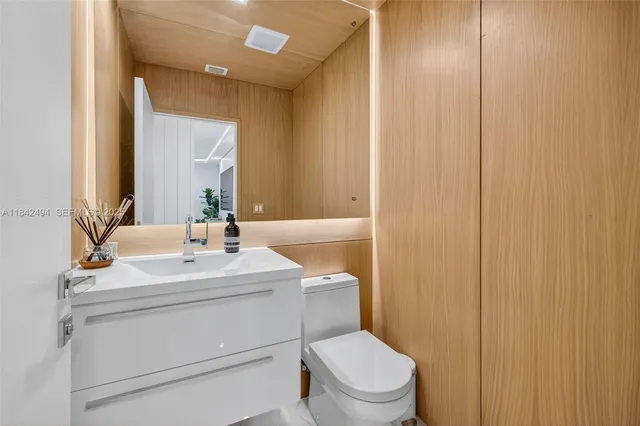 a bathroom with a toilet a sink and mirror