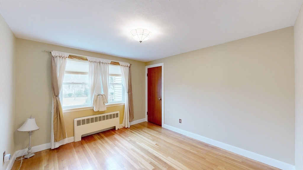 10 Wayland Road Wakefield, MA 01880 - Photo 15 of 28 a view of an empty room with a window and wooden floor