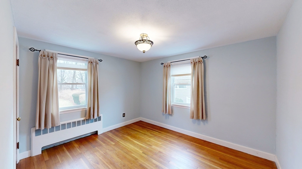 10 Wayland Road Wakefield, MA 01880 - Photo 17 of 28 an empty room with wooden floor and windows