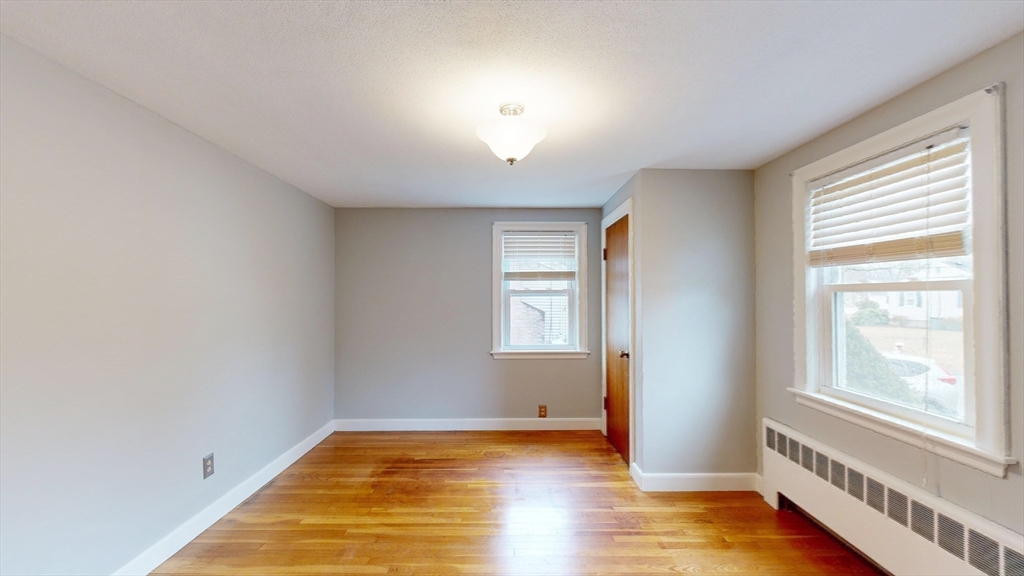 10 Wayland Road Wakefield, MA 01880 - Photo 19 of 28 a view of an empty room with wooden floor and a window