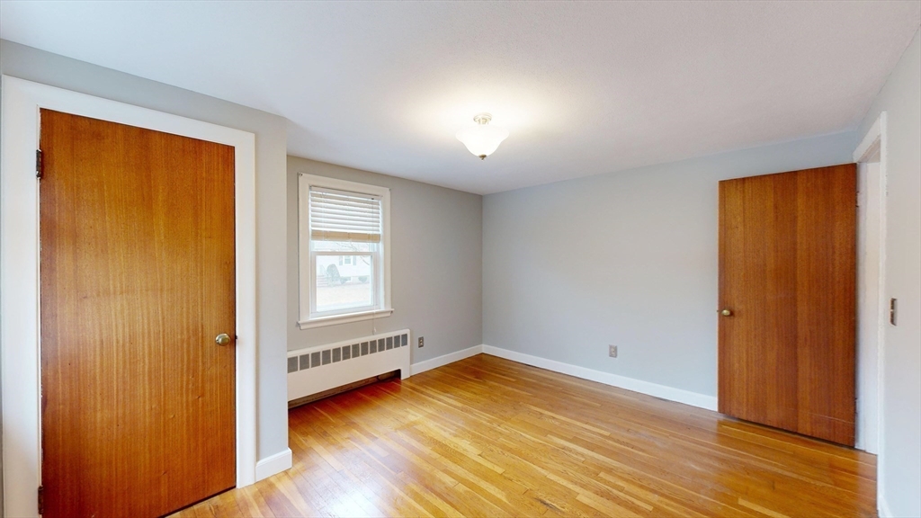 10 Wayland Road Wakefield, MA 01880 - Photo 20 of 28 a view of an empty room with wooden floor and a window