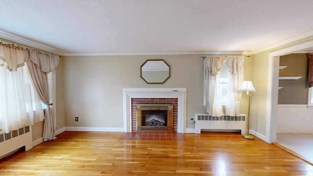 10 Wayland Road Wakefield, MA 01880 - Photo 7 of 28 a view of an empty room with wooden floor fireplace and a window