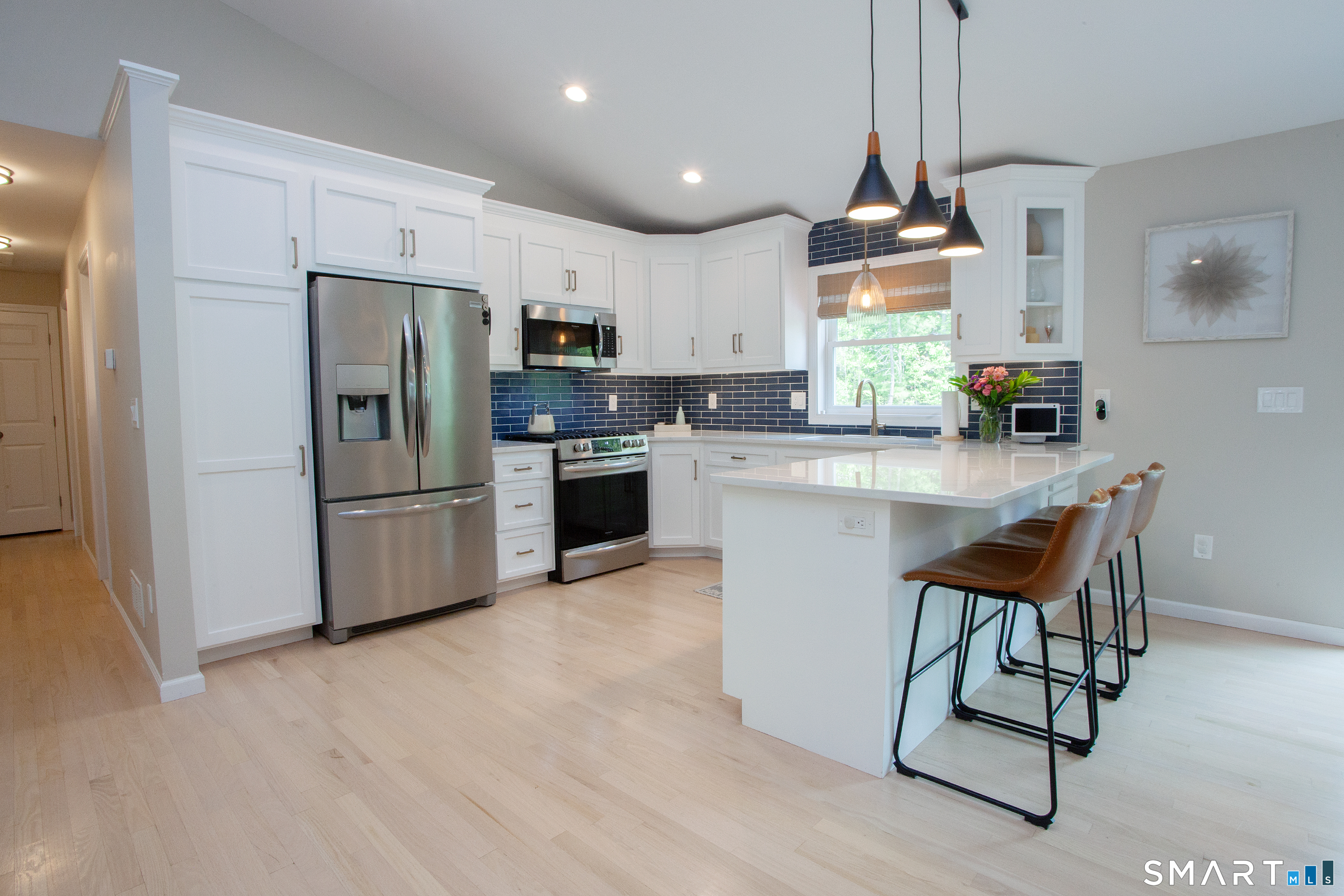 93 Rye Hill Circle Somers, CT 06071 - Photo 11 of 33 a kitchen with stainless steel appliances kitchen island granite countertop a refrigerator a stove a sink dishwasher and white cabinets with wooden floor
