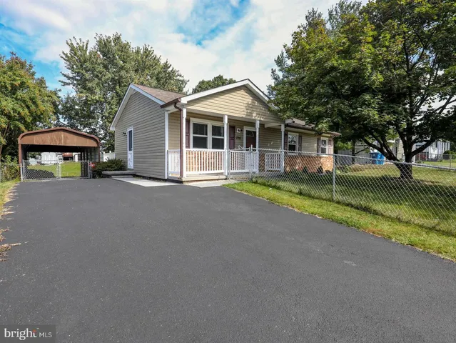 a view of a house with a yard and sitting area