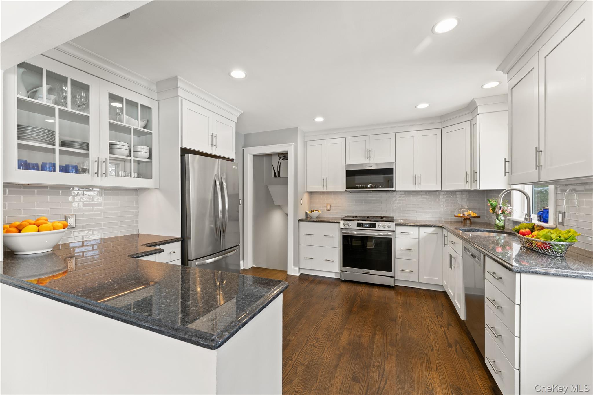 20 Riverview Road Irvington, NY 10533 - Photo 13 of 37 a kitchen with stainless steel appliances granite countertop a stove top oven a sink dishwasher a refrigerator and white cabinets with wooden floor