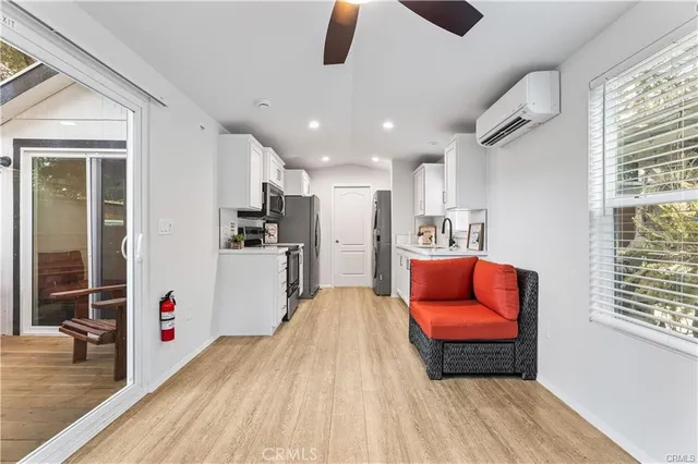 a hallway with stainless steel appliances kitchen island granite countertop furniture and a wooden floors