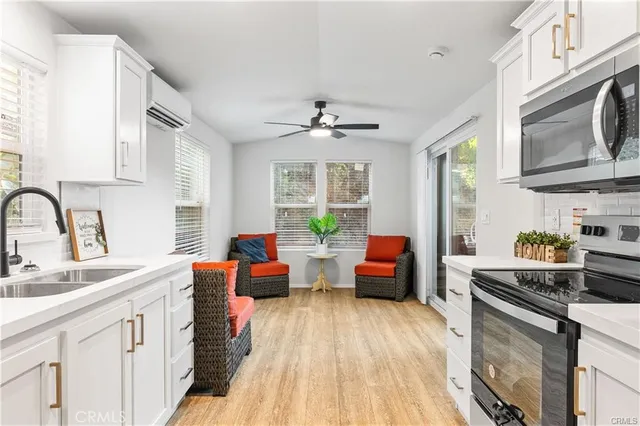 a kitchen with stainless steel appliances a stove a sink dishwasher and cabinets with wooden floor