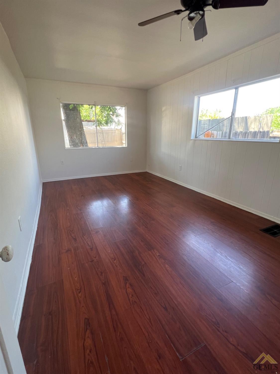 Undisclosed Address Taft, CA 93268 - Photo 11 of 18 an empty room with wooden floor and windows
