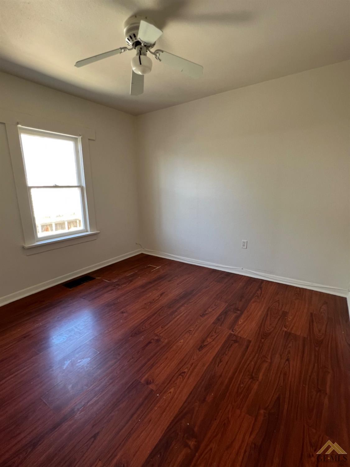 Undisclosed Address Taft, CA 93268 - Photo 12 of 18 an empty room with wooden floor chandelier and windows