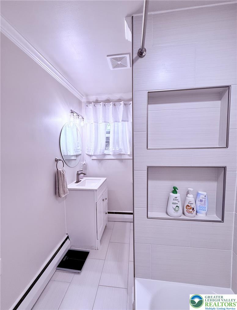 1275 Macada Road Bethlehem, PA 18017 - Photo 51 of 87 A pristine bath offers tiled flooring, a modern vanity, and a shower with built-in shelving.