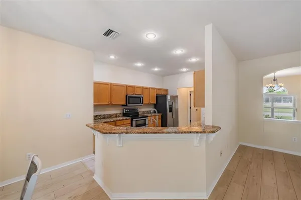 a kitchen with kitchen island a sink appliances and a counter top space